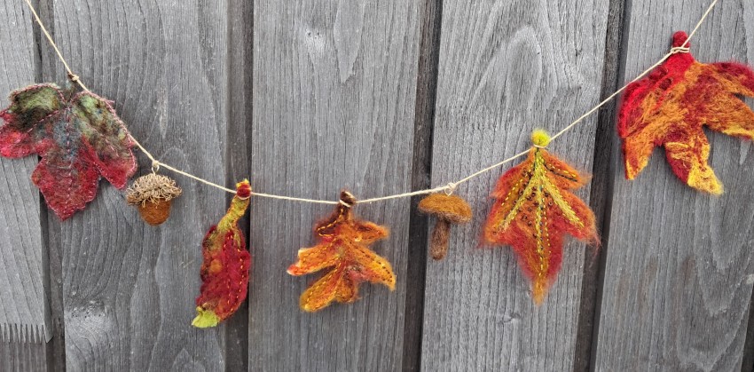 A felted garland with leaves, acorn and a mushroom