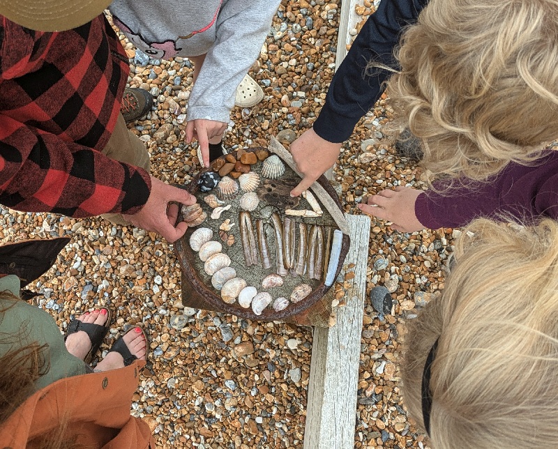 Photograph of a family group with beach finds on the shore at Rye Harbour Nature Reserve